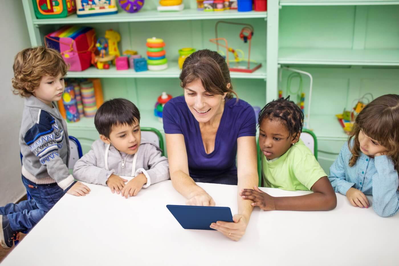 Kindergarten students learn from an iPad