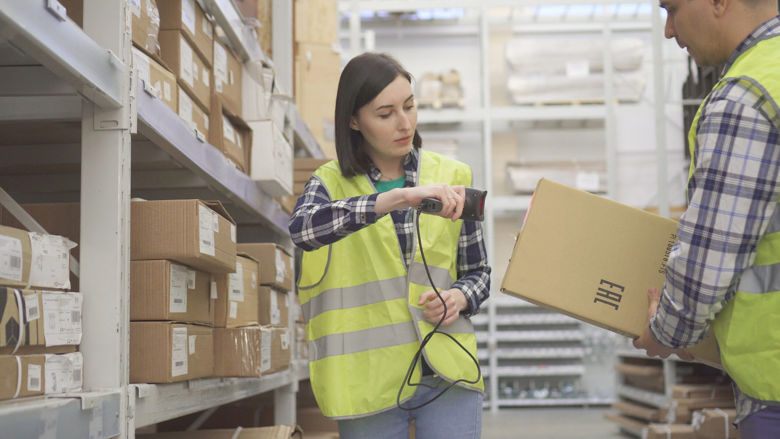 Shop assistant scanning package bar code in warehouse